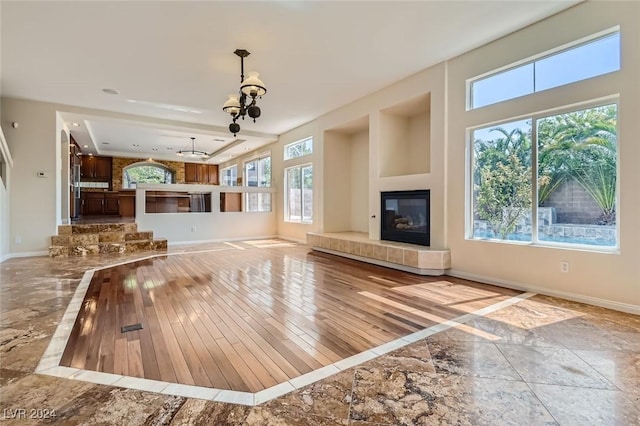 unfurnished living room featuring a tiled fireplace and plenty of natural light