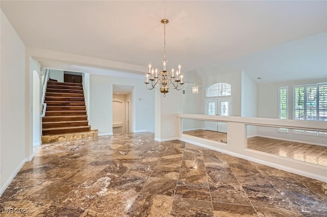 unfurnished dining area with lofted ceiling, french doors, and an inviting chandelier