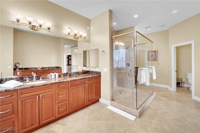 bathroom with tile patterned floors, vanity, toilet, and a shower with shower door