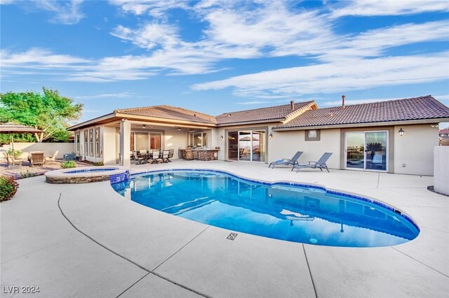 view of swimming pool featuring a patio area and an in ground hot tub