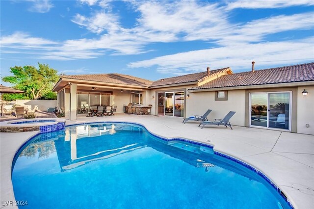 view of swimming pool featuring a patio area and an in ground hot tub