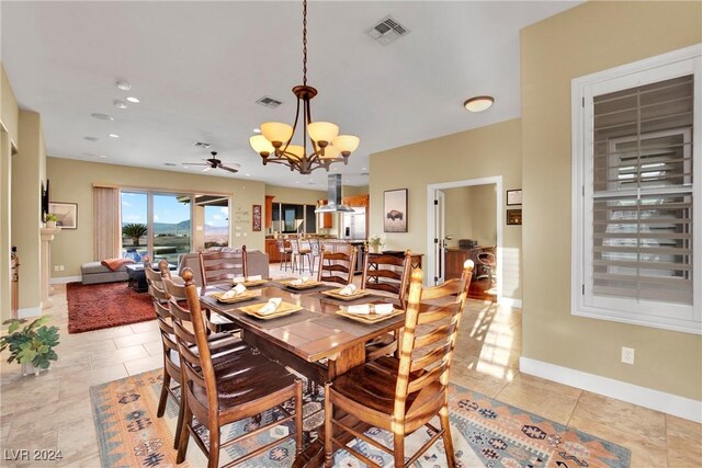 dining room with light tile patterned floors and ceiling fan with notable chandelier