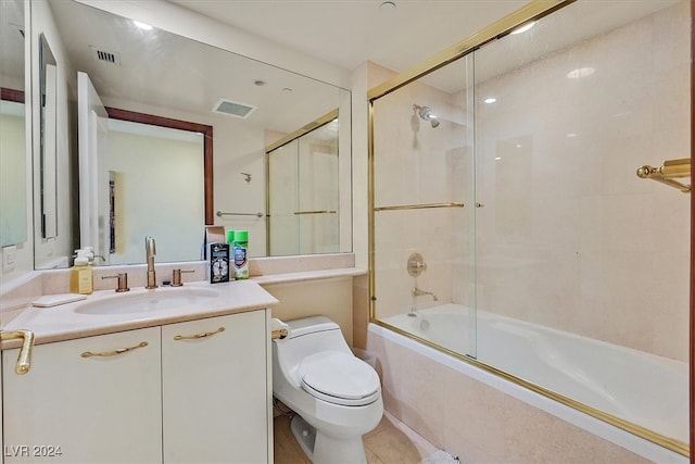 full bathroom featuring shower / bath combination with glass door, vanity, toilet, and tile patterned flooring