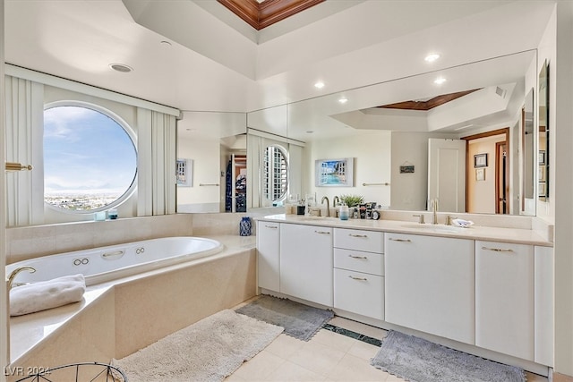 bathroom with tiled tub, vanity, a raised ceiling, and tile patterned flooring