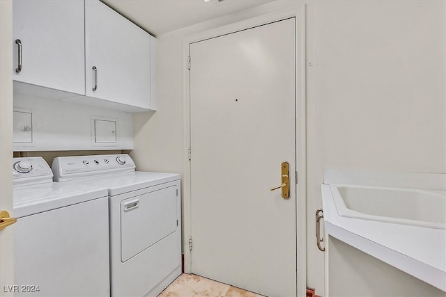 laundry room with cabinets, washing machine and dryer, and light tile patterned flooring