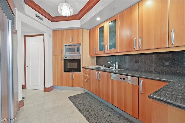 kitchen featuring crown molding, built in appliances, backsplash, an inviting chandelier, and sink