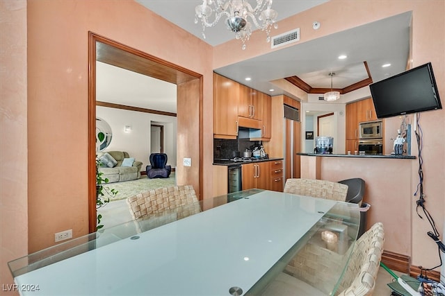 dining room with a tray ceiling, a chandelier, and ornamental molding