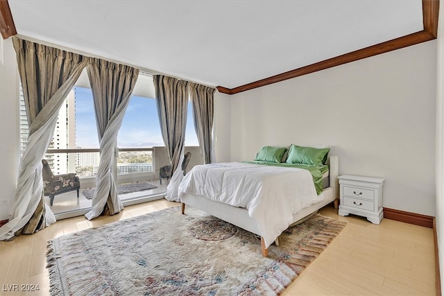 bedroom featuring crown molding and light hardwood / wood-style flooring