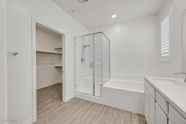 bathroom featuring vanity, hardwood / wood-style flooring, and shower with separate bathtub