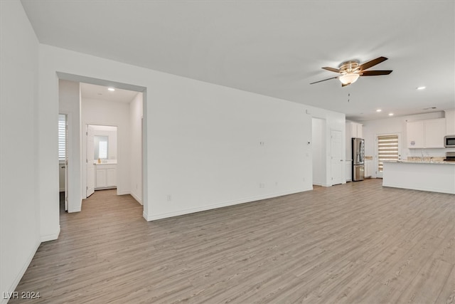 unfurnished living room featuring ceiling fan and light hardwood / wood-style floors