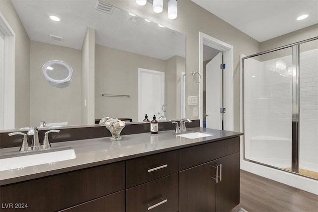 bathroom featuring a shower with door, vanity, and wood-type flooring