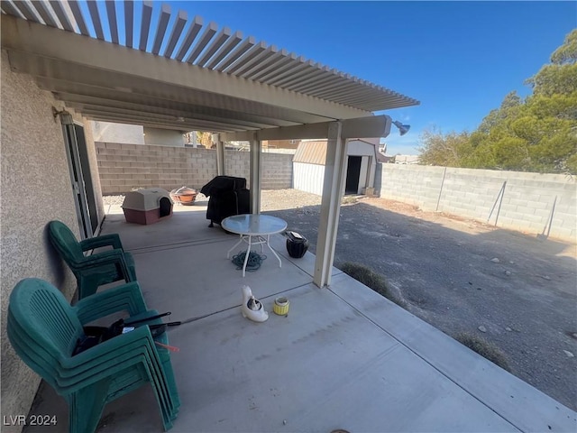 view of patio with an outbuilding, a storage shed, a fenced backyard, and a grill