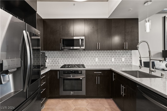 kitchen featuring decorative light fixtures, light stone countertops, stainless steel appliances, and decorative backsplash