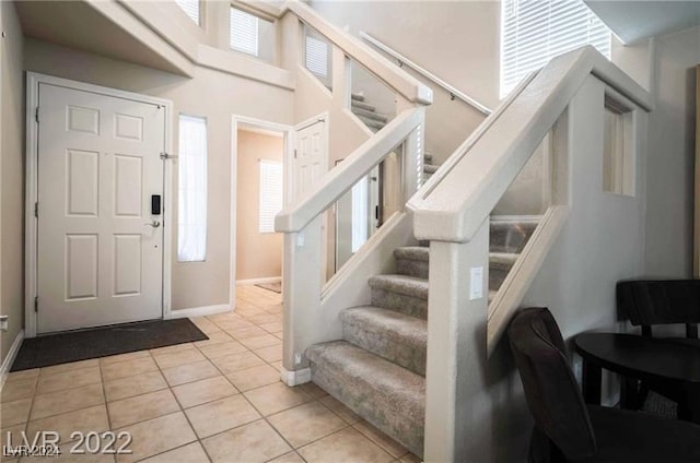 foyer featuring a towering ceiling and light tile patterned flooring