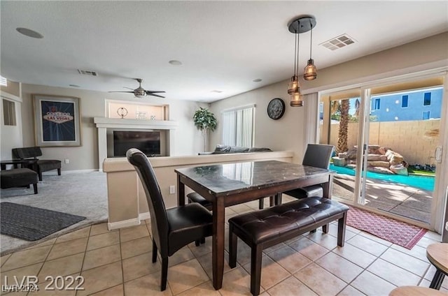 tiled dining space with ceiling fan