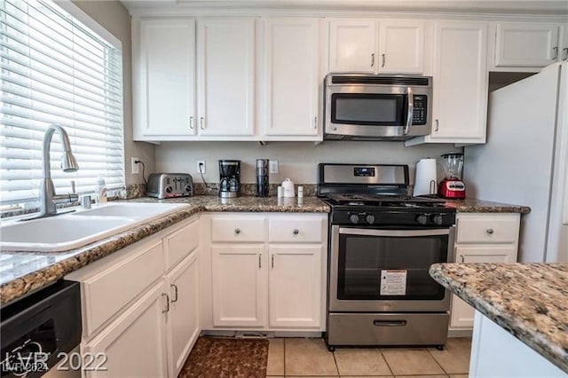 kitchen featuring a wealth of natural light, stainless steel appliances, and white cabinetry