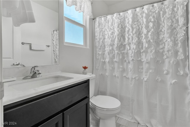 bathroom featuring vanity, toilet, a shower with curtain, and tile patterned floors