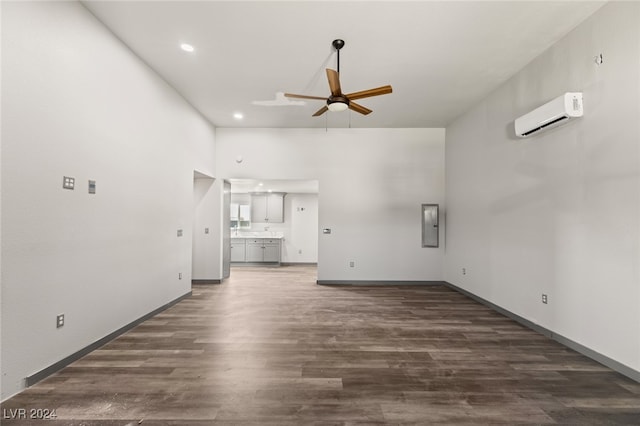 unfurnished living room featuring ceiling fan, electric panel, dark hardwood / wood-style floors, and a wall mounted air conditioner