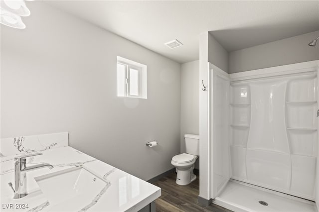 bathroom with a shower, wood-type flooring, toilet, and vanity