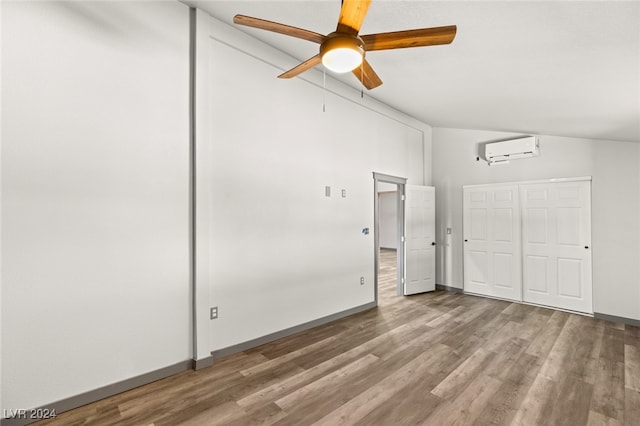 interior space featuring ceiling fan, an AC wall unit, and wood-type flooring