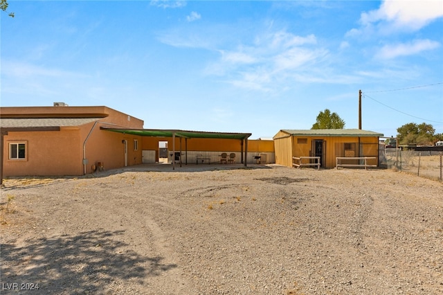 back of property featuring an outdoor structure