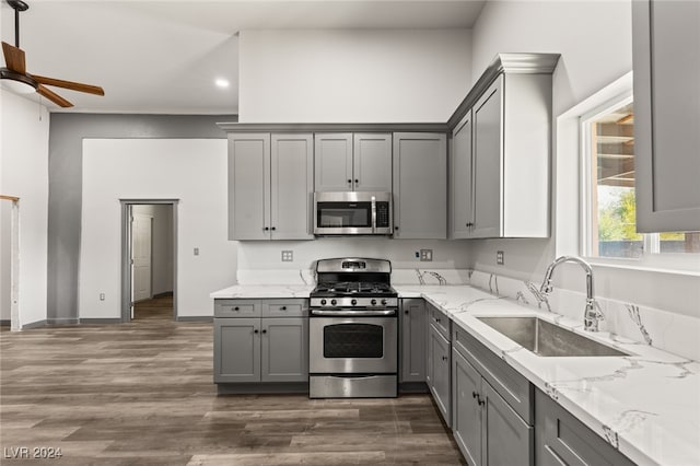 kitchen featuring dark hardwood / wood-style floors, appliances with stainless steel finishes, sink, gray cabinets, and ceiling fan