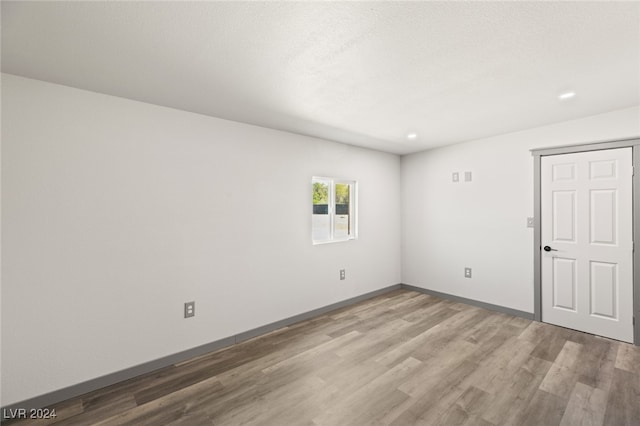 empty room featuring a textured ceiling and wood-type flooring