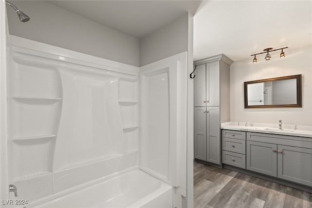 bathroom featuring vanity, wood-type flooring, and shower / washtub combination