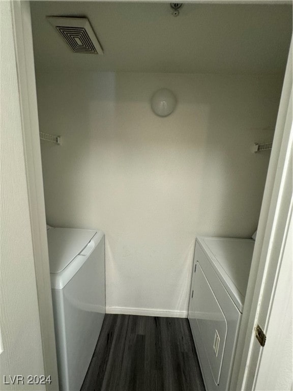 clothes washing area featuring washer and dryer and dark hardwood / wood-style floors