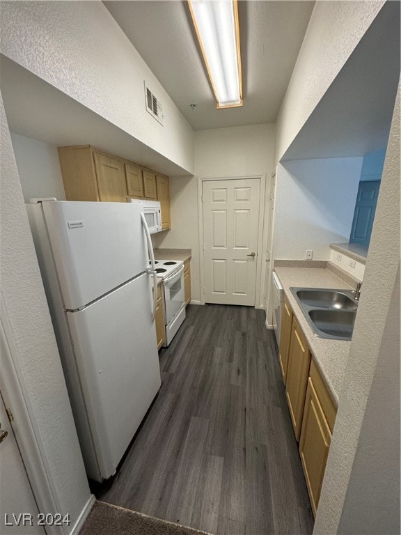 kitchen featuring white appliances, dark hardwood / wood-style flooring, and sink