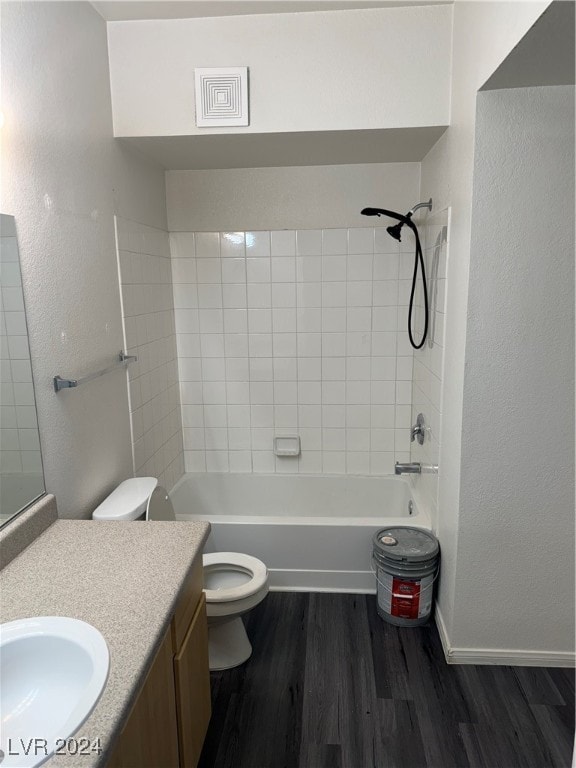 full bathroom featuring hardwood / wood-style floors, toilet, tiled shower / bath combo, and vanity