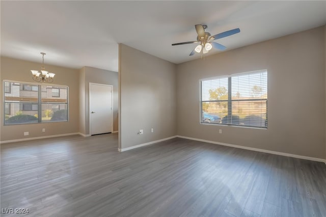 empty room with wood-type flooring and ceiling fan with notable chandelier