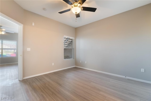 empty room with ceiling fan and light wood-type flooring