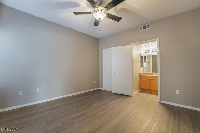 unfurnished bedroom featuring ceiling fan, connected bathroom, and light hardwood / wood-style flooring