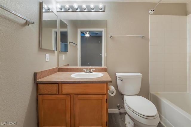 full bathroom featuring hardwood / wood-style floors, vanity, shower / tub combination, and toilet