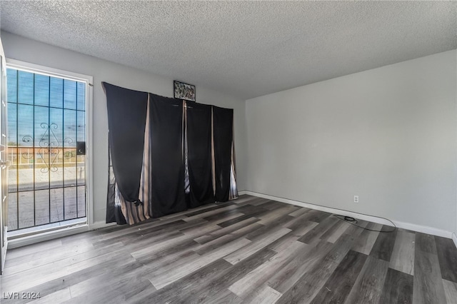 empty room featuring a textured ceiling and hardwood / wood-style floors