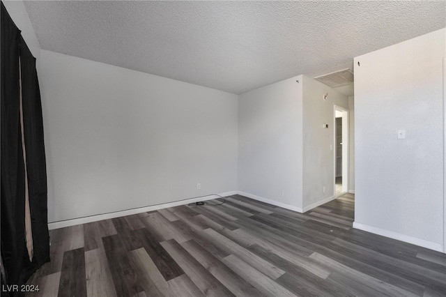 unfurnished room with a textured ceiling and dark hardwood / wood-style flooring