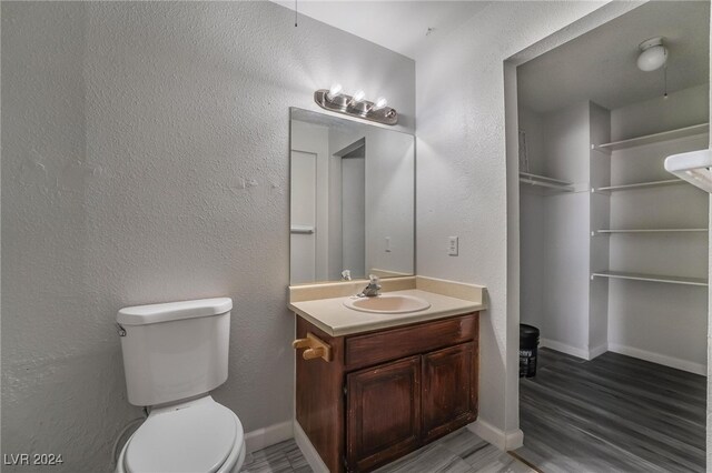 bathroom with hardwood / wood-style floors, vanity, and toilet