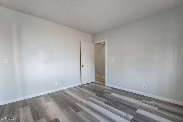 empty room with a textured ceiling and hardwood / wood-style floors