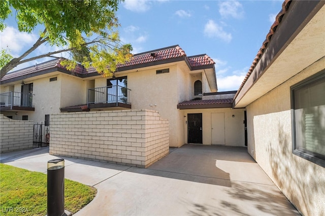 view of front of home with a balcony and a patio