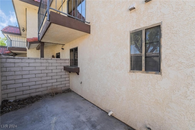 view of home's exterior featuring a balcony and a patio