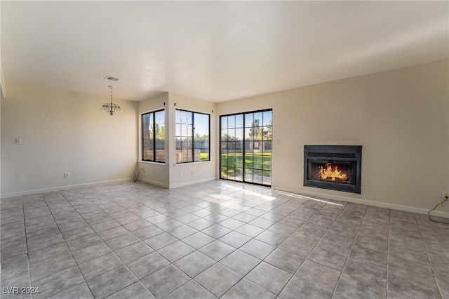 unfurnished living room featuring light tile patterned floors and a chandelier