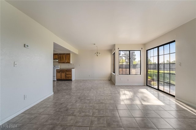 unfurnished living room with an inviting chandelier and light tile patterned floors