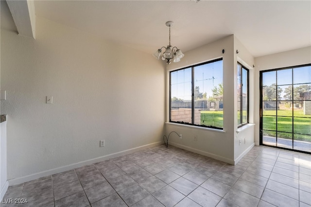 unfurnished dining area featuring an inviting chandelier, plenty of natural light, and light tile patterned floors