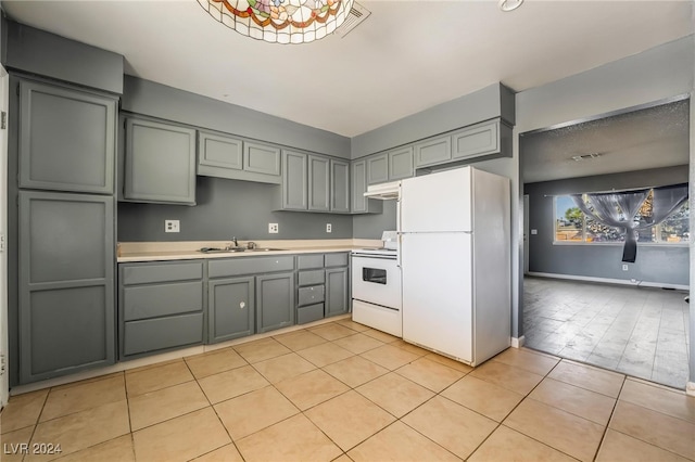 kitchen featuring light tile patterned floors, white appliances, gray cabinetry, and sink