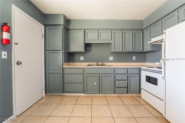 kitchen with sink, white appliances, and light tile patterned flooring