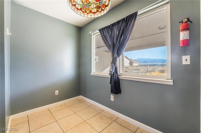 spare room with tile patterned flooring and a mountain view