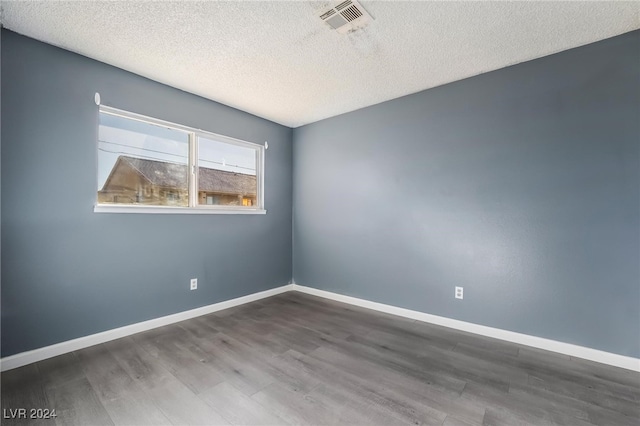 spare room with wood-type flooring and a textured ceiling