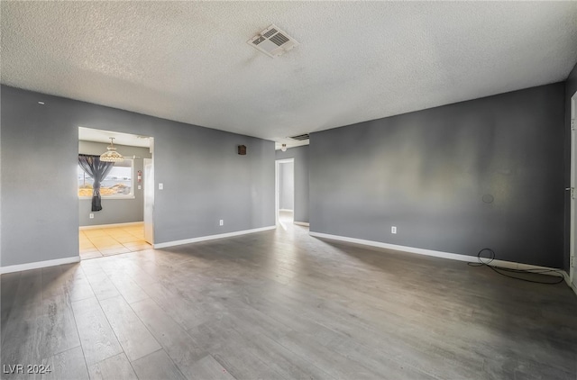 empty room featuring wood-type flooring and a textured ceiling