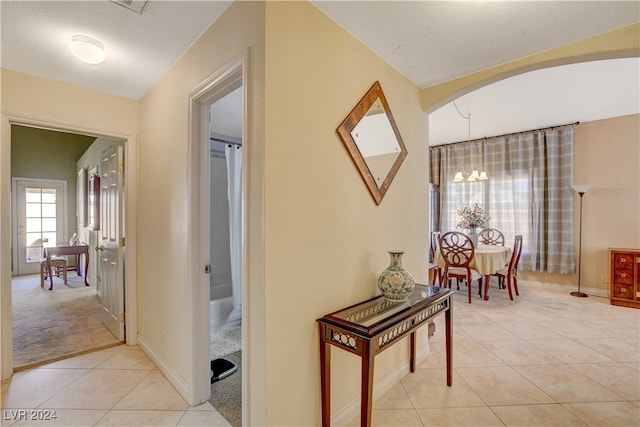 hallway with light carpet and lofted ceiling